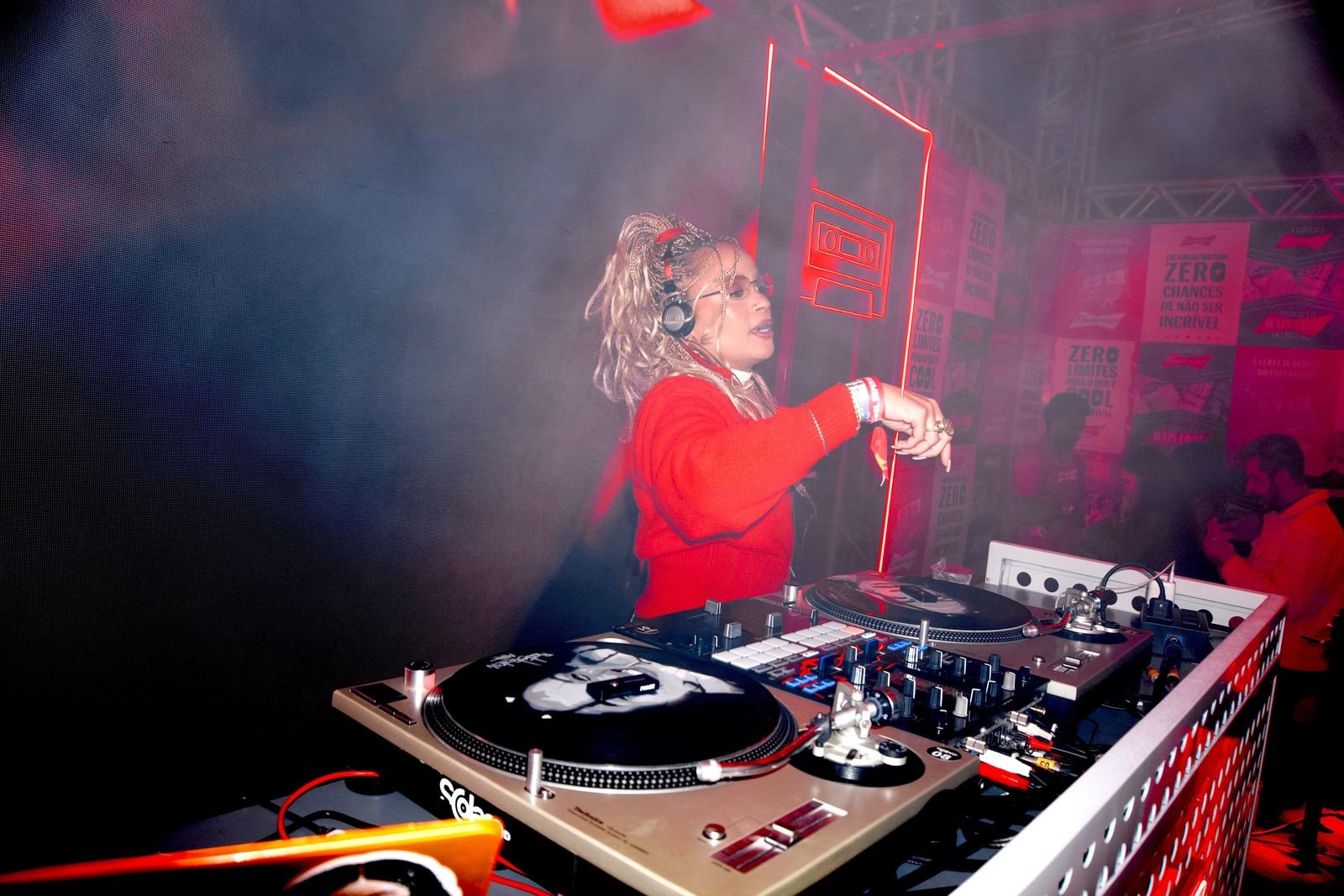 DJ Mitay tocando no palco da Budweiser no Coolritiba, luz vermelha e público ao fundo